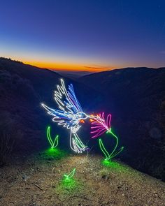 some lights that are on the ground in the dirt and grass with mountains in the background