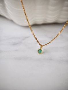 This tiny emerald necklace is the perfect daily necklace for emerald  lovers and May babies! The necklace is 14k gold filled with a beautiful natural Zambian Emerald pendant in a vivid green color in 18k solid gold setting. So beautiful! Layer it with your favorite necklaces, or wear it alone - it's perfect either way! The pendant is very small, approximately 4x7mm with a 3.5mm emerald. Each stone is unique and there will be slight variations in size. Emerald💚 Through time, the emerald has been Minimalist Gold Emerald Necklace With Delicate Chain, Dainty Gold Emerald Necklace With Delicate Chain, Gold Dainty Emerald Necklace, Dainty Gold Emerald Round Necklace, Dainty Emerald Necklace With Delicate Chain For Everyday, Gold Emerald Birthstone Necklace In Minimalist Style, Minimalist Gold Emerald Gemstone Necklace, Gold Emerald Necklace With Delicate Chain For Gift, Gold Minimalist Emerald Birthstone Necklace