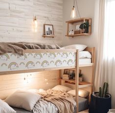 there is a bunk bed with a rainbow print on the bottom and two shelves above it