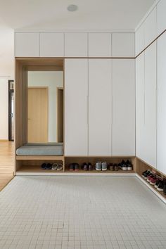 an empty room with white cabinets and shoes on the floor