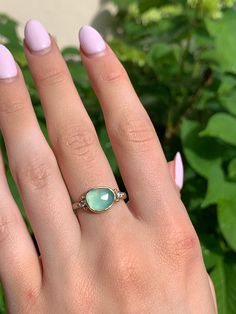 A seafoam green chrysoprase is set in 14k yellow gold a top a sterling silver seagrass band. Accented with small handmade gold beads. Approx stone size: 12mm x 10mm Approx stone weight: 2.9cts Mohs Hardness: 6-7 This one of a kind piece is handmade in Emily's Hudson Valley studio. If you have questions about sizing, shipping or need help deciding please reach out to us! Chrysoprase Ring, Mohs Hardness Scale, Local Jewelry, We Can Do It, Handmade Gold, Seafoam Green, Hudson Valley, Cocktail Ring, Sea Foam