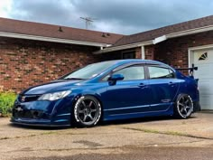 a blue car parked in front of a house