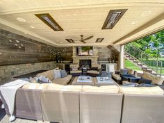 an outdoor living area with couches, tables and a fire place in the center