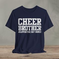 Cheer Brother Supportive But Bored - Cheerleader Brother  : - Classic unisex jersey short sleeve tee made from soft cotton.   - Quality print ensures durability and attractiveness. - Features ribbed knit collars for shaping and tapered shoulders for better fit. - Dual side seams maintain garment shape over time. - Made from 100% lightweight Airlume combed and ring-spun cotton (4.2 oz/yd²). - Ideal for layering, breathable, suitable for active and leisure wear. - Retail fit suitable for casual and semi-formal wear. - Crew neckline for classic style, easy to accessorize. - Manufactured by Bella+Canvas in the US and internationally with humane, sustainable practices. - Certified by Fair Labor Association and Platinum WRAP. - Tear-away label minimizes skin irritations. - Fabric blends include Cotton Team Spirit T-shirt With Slogan, Funny Text Crew Neck T-shirt For College, Cotton Slogan T-shirt For Fan Gear, Graphic Tee T-shirt For Cheerleading, School Spirit Short Sleeve T-shirt With Letter Print, College T-shirt With Funny Text And Short Sleeves, Game Day Graphic Tee With Slogan, Graphic Tee With Slogan For Game Day, Game Day Slogan Graphic Tee