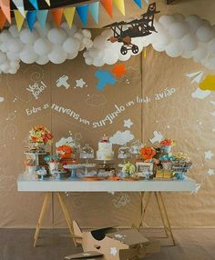 an airplane themed birthday party with balloons and desserts on a table in front of a backdrop