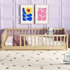 a baby crib with two paintings on the wall