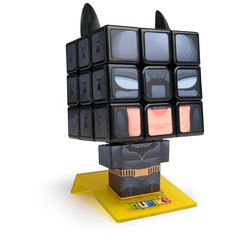 a toy made out of cubes on top of a yellow stand with batman's face