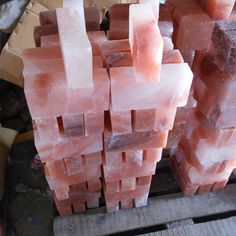 several pieces of pink soap sitting on top of a wooden pallet next to each other