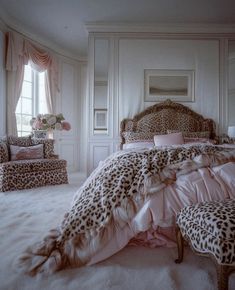 a leopard print bed in a white bedroom with pink pillows and foot stools on the floor