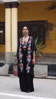 Planning for an upcoming wedding cocktail? Look no further! This exquisite ensemble is designed to make you shine. Introducing the Black Floral Embroidered Patchwork Cape Set, a stunning choice for those seeking elegance in cocktail and party ethnic wear for women. This fashionable cape set showcases beautiful floral embroidery designs that elevate its charm and sophistication. Festival Sets With Resham Embroidery And Cape Sleeves, Festive Embroidered Palazzo Set With Cape Sleeves, Embroidered Festival Sets With Cape Sleeves, Festival Embroidered Sets With Cape Sleeves, Traditional Wear With Resham Embroidery And Cape Sleeves, Traditional Chikankari Embroidery Dress With Cape Sleeves, Bollywood Embroidered Palazzo Set With Cape Sleeves, Designer Traditional Wear With Embroidered Cape Sleeves, Designer Embroidered Traditional Wear With Cape Sleeves