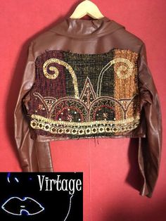 Customized 70s leather jacket.  A cropped 70s jacket, with attached embroidered piece in the back No lining Please check fit carefully. MEASUREMENTS (taken flat) SIZE  marked on item:  Aprox. modern size:  SHOULDER : 13cm SLEEVE : 59 cm BUST: 45cm LENGTH: 42 cm MATERIAL /F A B R I C : real leather,  semio soft quality leather in the back: attached embroidered with plastic pearls and wood pearls,  woven part COLOR:  caramel brown  CONDITION: fine vintage condition Item not pinned on model. For re 70s Leather Jacket, Indian Summer Dress, Vintage Website, 70s Jacket, Hippie Jacket, Bohemian Outfits, Vintage Dress 70s, 80s And 90s Fashion, Brown Suede Jacket