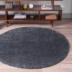 a living room with a rug on the floor and a book shelf next to it