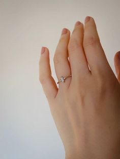 a woman's hand with a diamond ring on it