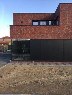 a large brick building with glass doors on the front and side windows that are open