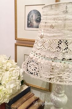 white flowers are sitting on a table next to an old book and lace doily