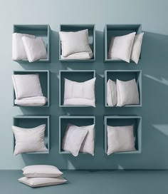 pillows and pillow cases are arranged on the wall in an empty room with blue walls