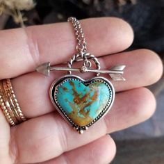 "Genuine Kingman, Arizona turquoise heart is set in a handcrafted oxidized 925 sterling silver bezel with accents of 14k gold. Front closing arrow toggle closure features a Moissanite diamond for a touch of sparkle. Connects  to a 1.5mm lightweight and sturdy rolo chain.  ~Heart pendant in main listing pictures is sold. Please choose B or C to be set for you! ~1.25\" x 1\" heart pendant  ~Wrapped in black gift box ~Handmade in Tennessee" One Of A Kind Turquoise Jewelry For Anniversary, Heirloom Sterling Silver Jewelry With Heart Charm, Unique Heart Charm Pendant Jewelry, Heirloom Turquoise Jewelry For Gift, Heirloom Turquoise Jewelry Gift, Unique Gemstone Heart Pendant Jewelry, Unique Turquoise Jewelry For Anniversary, Artisan Turquoise Jewelry For Anniversary, Artisan Heart-shaped Jewelry For Anniversary