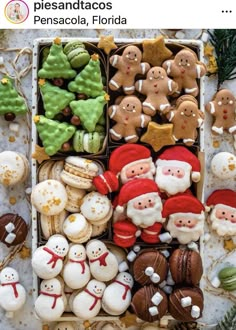 an assortment of christmas cookies in a box with santa clause and other decorations on the table