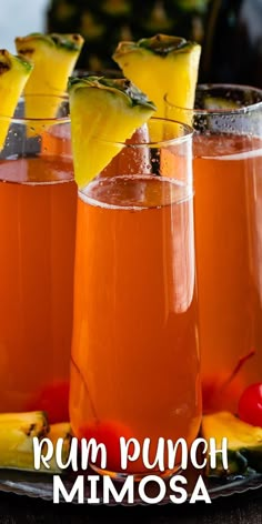 three glasses filled with rum punch and garnished with pineapple slices on a plate