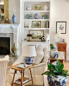 a living room filled with furniture and a fire place in front of a white fireplace