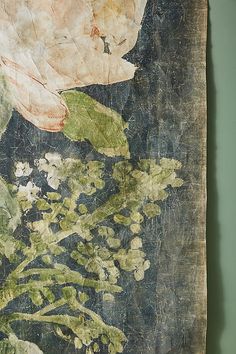 an old piece of paper with flowers and leaves painted on the back side of it