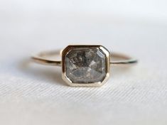 a close up of a diamond ring on a white surface with the background blurred out