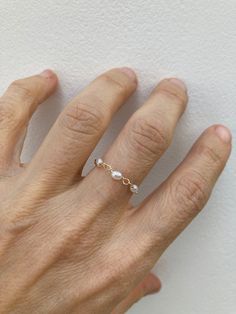 This little chain ring offers a fresh take on a traditional band ring. It is also very lightweight and comfortable to wear.  D E T A I L S *Made with AAA grade cultured freshwater rice pearls. These are very small measuring between 2- 4mm x 1.5mm. *Choose between a 14k gold filled or sterling silver chain. *Gold fill is a wonderful alternative to gold and unlike gold plating does not rub off. *Choose the size you prefer from the drop down menu.  *Ring comes with a matching crystal information ca Dainty 14k Rose Gold Pearl Ring, Dainty Pearl Chain Ring For Wedding, Dainty Wedding Pearl Ring With Pearl Chain, Adjustable Dainty Rose Gold Pearl Ring, Adjustable Rose Gold Dainty Pearl Ring, Freshwater Pearl Ring, Gold Filled Ring, Chain Ring, Minimalist Rings