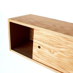 a wooden cabinet with its door open on a white background, showing the bottom section