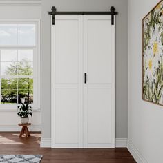 an empty room with white closets and wood flooring in the center, along with a rug on the floor