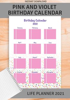 the pink and violet birthday calendar is displayed on a wooden table