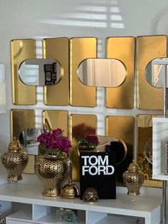 a white table topped with gold vases and mirrors