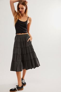 **Improved Fit!** *You asked, we listened — we reimagined our original In Full Swing Midi Skirt with an all-around elastic design for a more true-to-size fit.* So effortless and chic, this midi skirt is featured in a poplin fabrication and low-rise fit with a tiered silhouette and elastic waistband. **Fit:** Low-slung, billowy silhouette **Features:** Poplin fabrication, lightweight design, stretchy elastic waistband, tiered design, A-line hem **Why We ❤ It:** This timeless skirt can be dressed Tiered Skirt Outfit, Black Midi Skirt Outfit, Midi Skirt Outfit, Tiered Midi Skirt, Free People Skirt, Boho Skirts, Mid Length Skirts, Black Midi Skirt, Tier Skirt