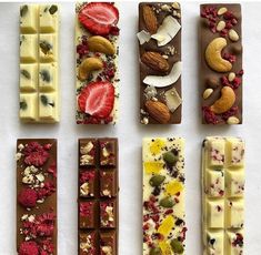 six different types of chocolates with nuts and fruit on them, all lined up in the same row