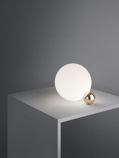 a white light sitting on top of a table next to a silver object in the middle