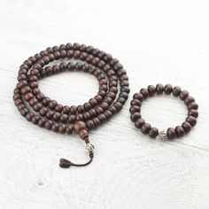 This authentic 108 bead mala is made with beautiful dark Bodhi beads and a white metal mantra bead. It features the mantra of compassion, Om Mani Padme Hum, in Tibetan script. Wearing or meditating with this mala will remind you to be compassionate and kind. The larger size of these beads can be very satisfying for counting. When not in use, it can be wrapped 3-5 times loosely around most wrists. Simply strung on heavy cotton cord and finished with a Bodhi guru bead. Handmade by Tibetan artisans Tibetan Script, Om Mani Padme Hum, Wrist Mala, 108 Mala Beads, 108 Bead, Mala Bracelet, Mala Beads, Mantra, White Metal