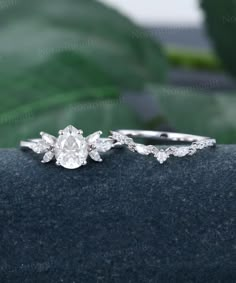 a close up view of a diamond ring on top of a blue surface with leaves