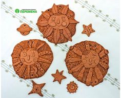 three wooden ornaments are shown on a white tablecloth with stars and circles around them