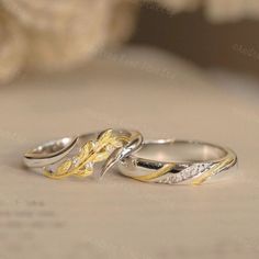 two wedding rings sitting on top of a table