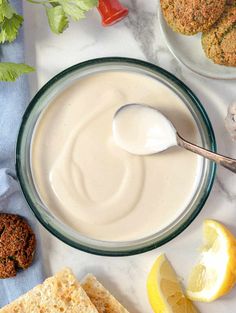 a bowl of yogurt next to crackers, lemons and other foodstuffs