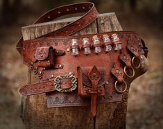 a brown leather purse sitting on top of a wooden stump in the woods with lots of rivets