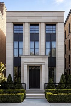 the front entrance to an apartment building with trimmed hedges