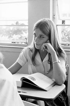 a woman sitting at a desk with an open book