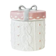 a white and pink ceramic cookie jar with a bow on the top that is decorated with hearts