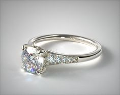 a white gold engagement ring with an oval cut diamond and pave set side stones