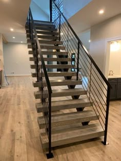 a stair case with metal railing and wood flooring