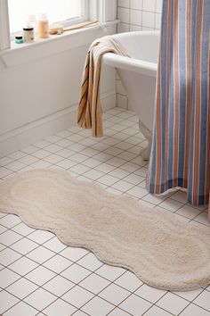 a bathroom with a bathtub, rug and shower curtain in it's corner