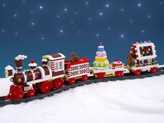 a toy train with christmas decorations on the front and sides in the snow, against a blue background