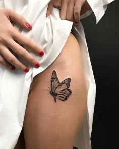 a woman's thigh with a butterfly tattoo on her left side ribcage