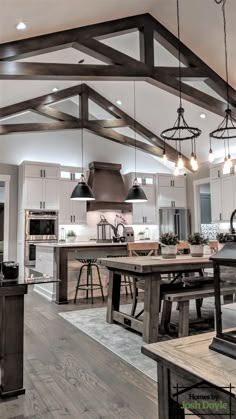 an open kitchen and dining room with wooden beams