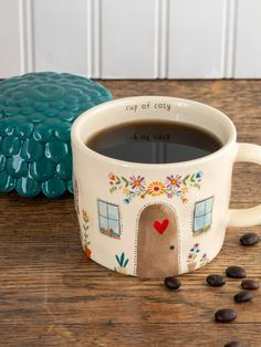 a cup of coffee sitting on top of a wooden table next to some chocolate chips